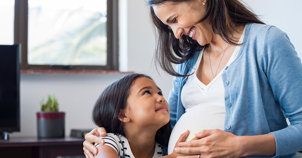 Mujer embarazada sonriente y niña