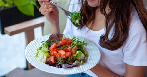 Mulher a comer salada