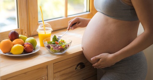 Mulher grávida a preparar salada