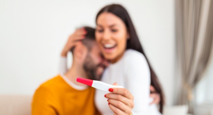 Casal com um teste de gravidez positivo.