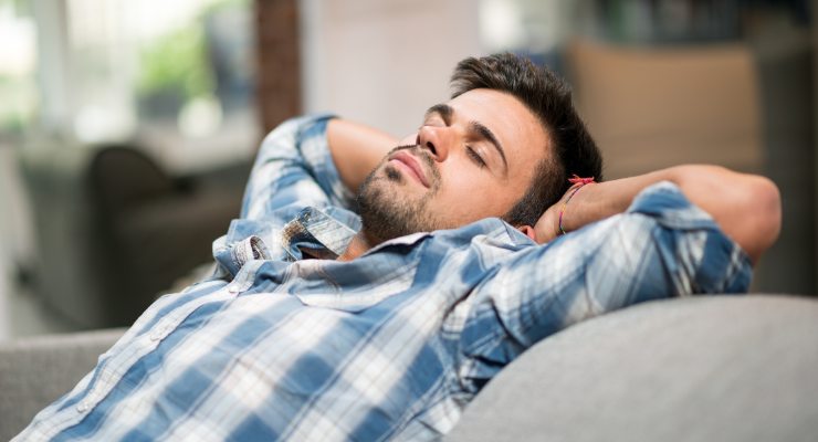 Homem relaxado sem dor de cabeça no sofá