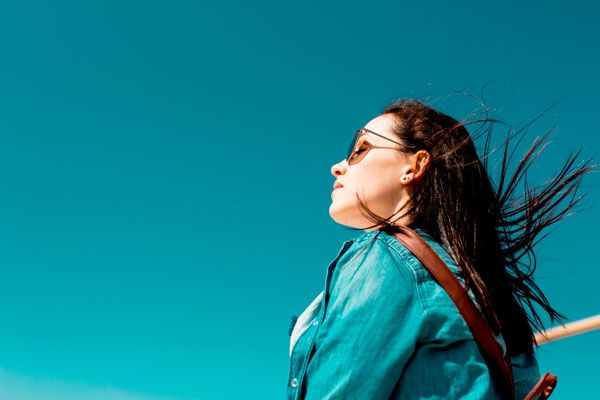 Mujer con gafas de sol mirando el cielo