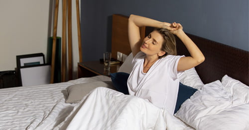 Mujer con menopausia levantándose tras dormir bien.