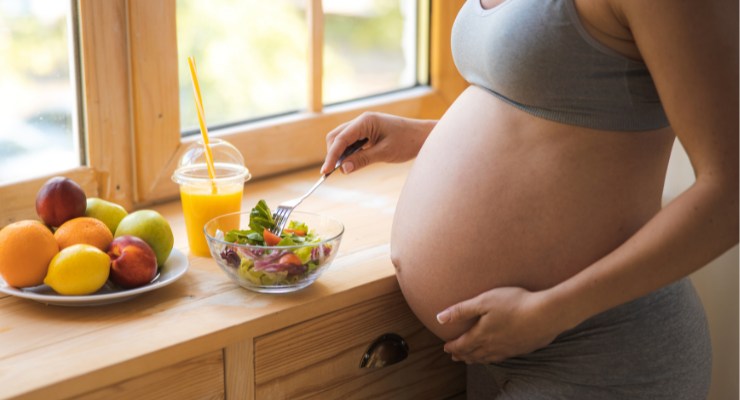 Mujer embarazada comiendo alimentos ricos en hierro