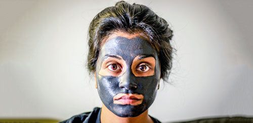 Mujer con mascarilla facial para evitar el envejecimiento prematuro.