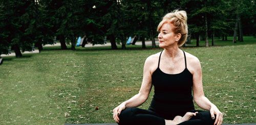 Mujer practicando yoga para combatir el envejecimiento prematuro en la menopausia