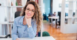 Mujer sonriendo sentada en su despacho