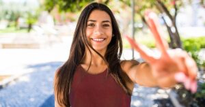 Mujer joven sonriente levantando dos dedos