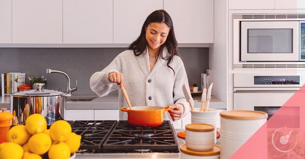 Mujer cocinando siguiendo dieta para quedar embarazada