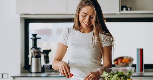 Mujer preparando comida saludable.