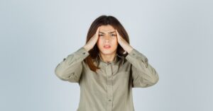 Mujer enfadada con las manos en la cabeza.