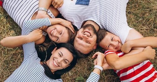 Familia tirada en la hierba sonriendo e hipercolesterolemia familiar