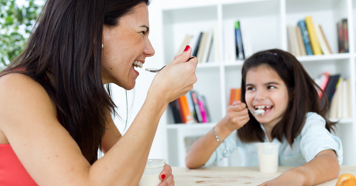 Madre e hija comiendo yogurt y qué son los probióticos