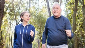Padre e hija haciendo deporte por el bosque