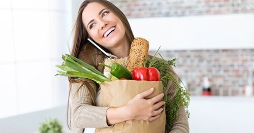 chica con bolsa de la compra llena de verduras y dieta para bajar el colesterol