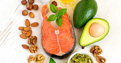 rodaja de salmón, aguacate y frutos secos y dieta para bajar el colesterol