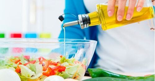 aliñando ensalada con aceite y cómo bajar el colesterol
