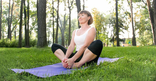 Mujer con perimenopausia practicando yoga en un parque