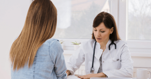 Ginecóloga explicando a paciente las causas de la menopausia precoz