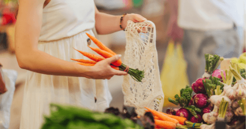 Mujer comprando zanahorias, alimentos bajos en dieta FODMAP