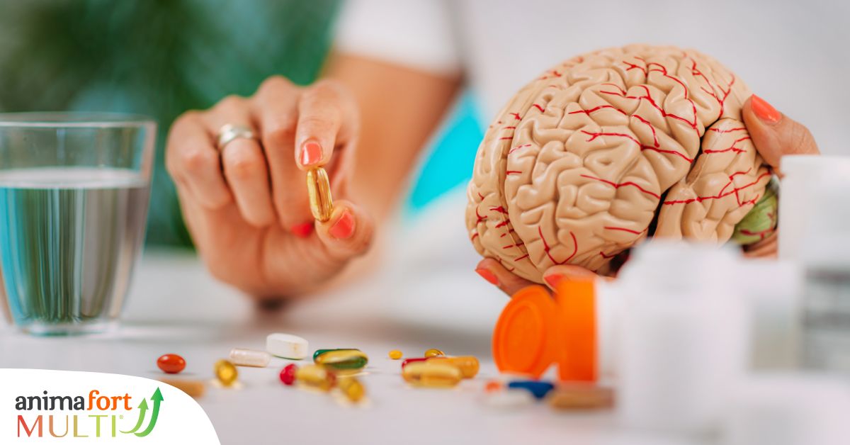 Manos de mujer sosteniendo pastillas para la ansiedad y una maqueta de un cerebro