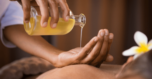 Primer plano de un masaje con aceite corporal para tratar la dermatitis