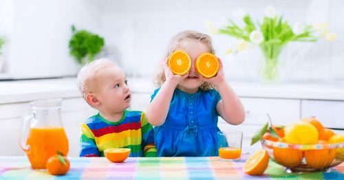 Bebés tomando zumo de naranja.