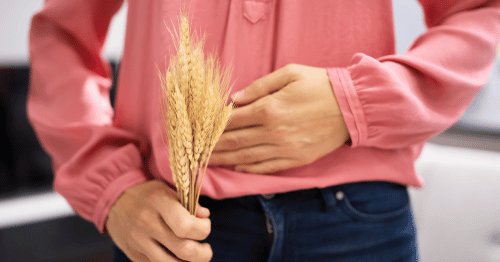 Hombre sosteniendo trigo, cuyo gluten puede producir inflamaciones relacionadas con el intestino y la piel