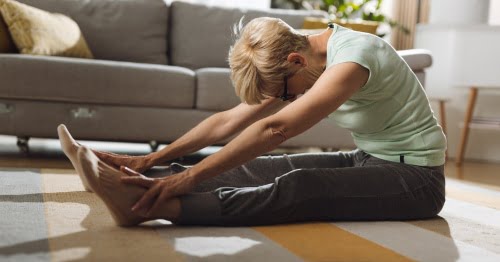 Mujer practicando yoga en el salón de su casa
