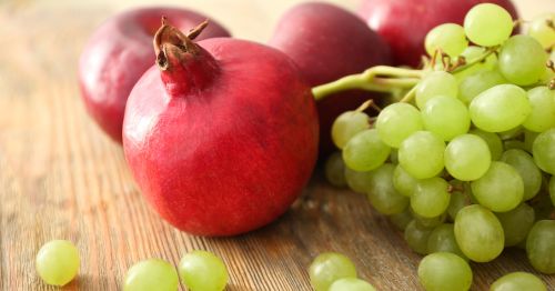 Uvas verdes y granadas sobre una mesa