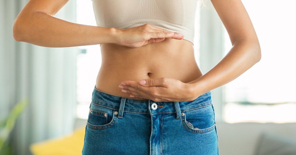 Cabecera del artículo sobre las opiniones de Emitium Intestinal con mujer con manos sobre el vientre