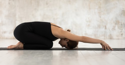 Mujer practicando una postura de yoga para aliviar el dolor menstrual