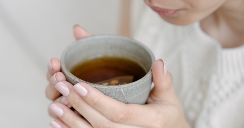 Mujer tomando infusión para el dolor menstrual