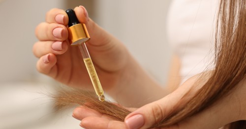 Mujer aplicando sérum con las mejores vitaminas para el cabello dañado