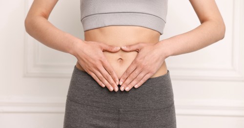 Mujer con manos sobre el abdomen e intestino saludable