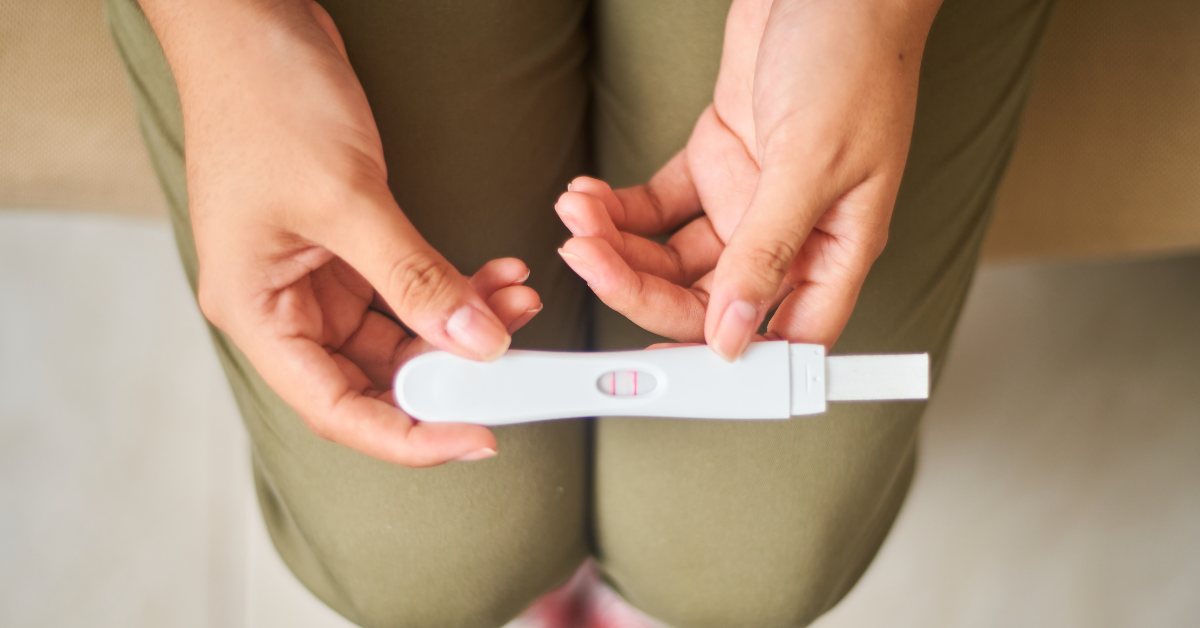 Mujer sosteniendo un test de embarazo positivo