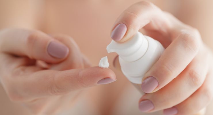 Mujer con un bote de crema hidratante vaginal